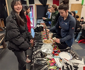 Students gathered around a decorated table at a school cultural fair event