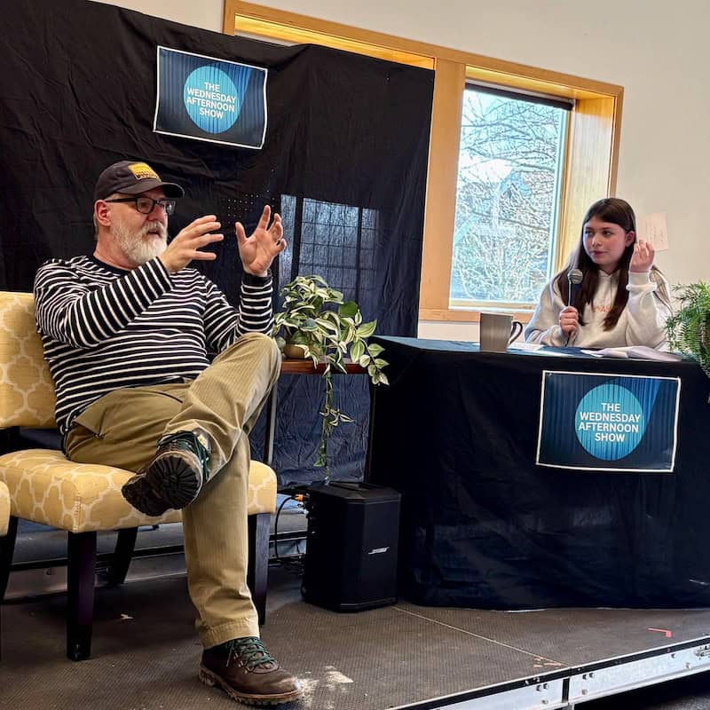 Talk show guest Forrest Kenworthy, WSA Humanities teacher, being interviewed by host Everly Lindgren