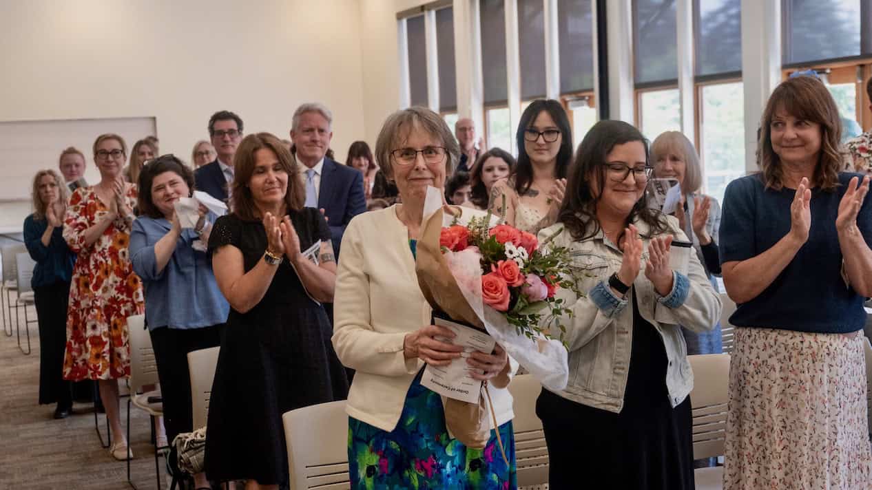 Karen_with_thank_you_bouquet_Graduation_May-30-2026 Karen Mattick receives bouquet and applause in honor of her retirement from teaching at WSA