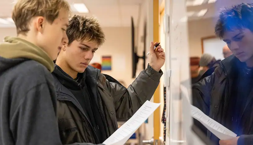 West Sound Academy The IB approach copy Students working together at a whiteboard, one writing out a problem