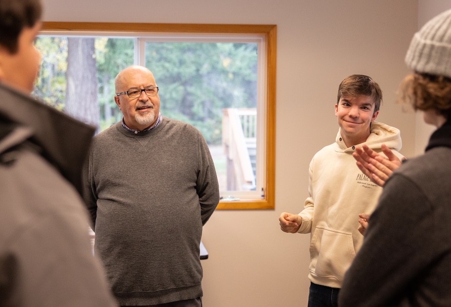 IB Math teacher in discussion with three seniors